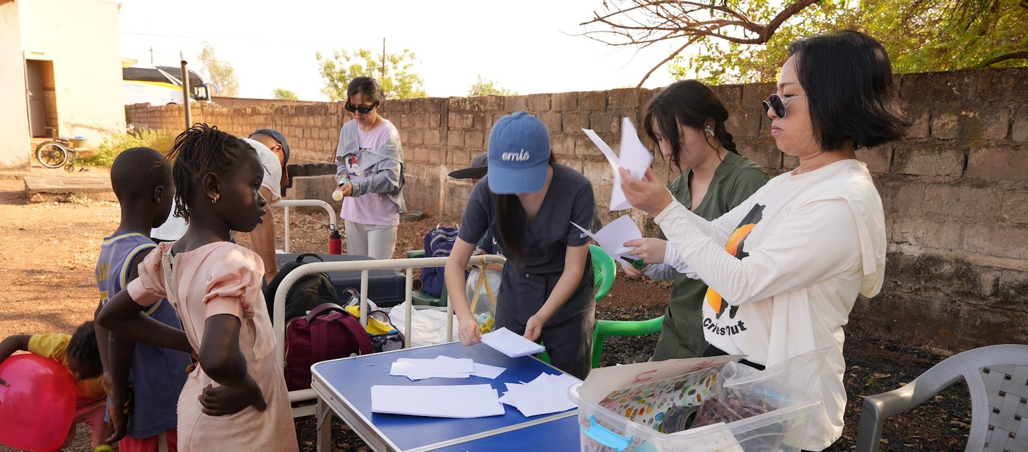ACO volunteers handing out supplies to children at a community outreach in Senegal