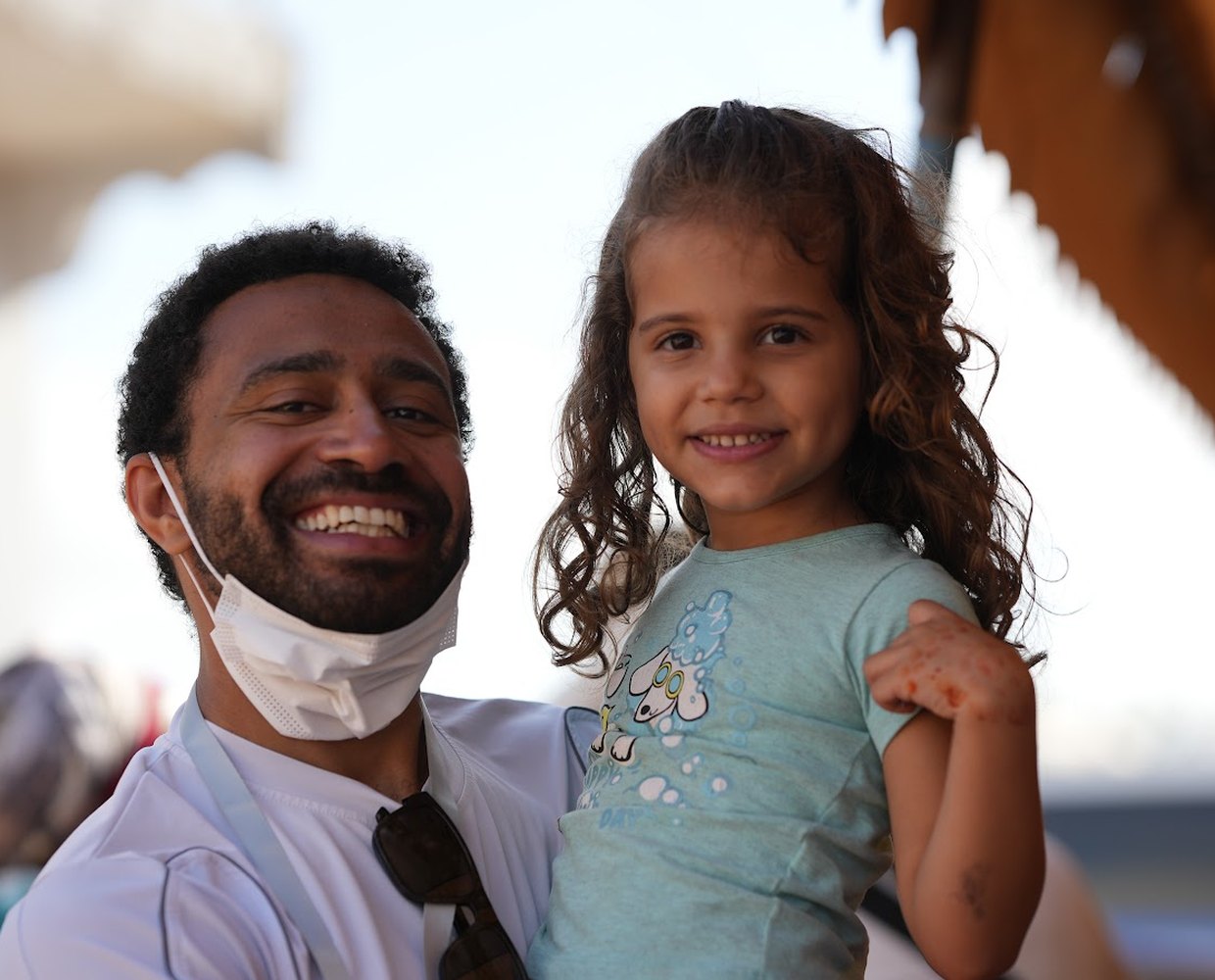 An ACO medical volunteer smiling with a young girl he is caring for during a mission outreach