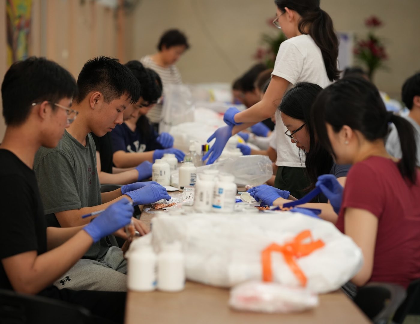ACO volunteers around a long table sorting and bagging donated medication for the mission clinics