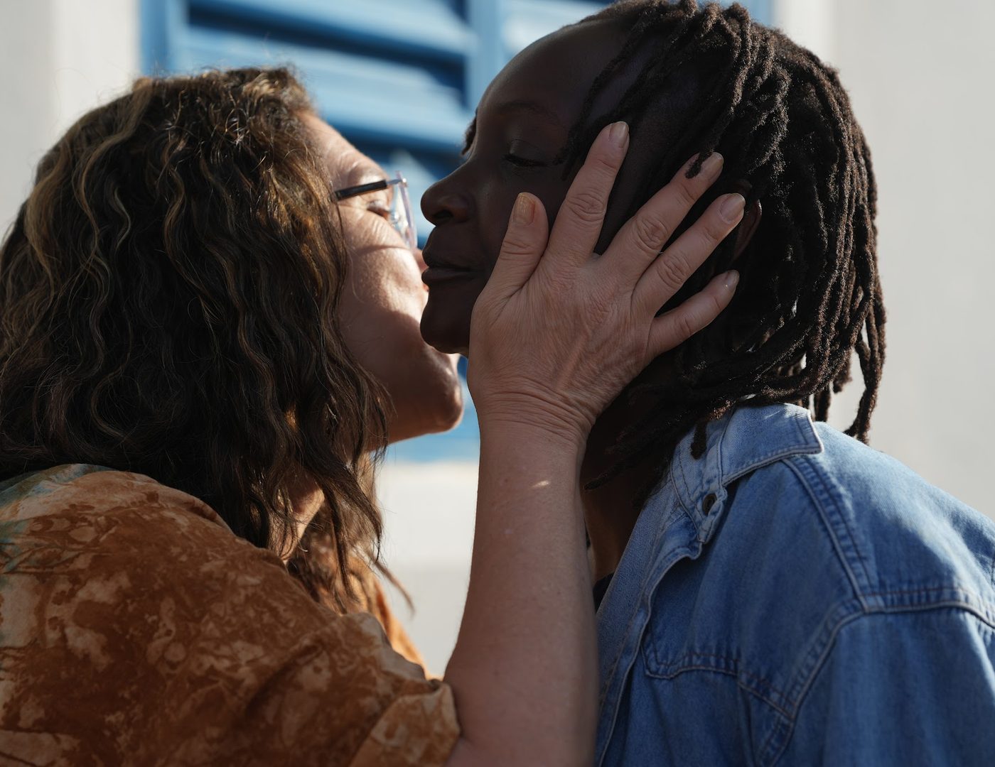 An ACO volunteer holding a woman's face in both hands as they speak quietly together