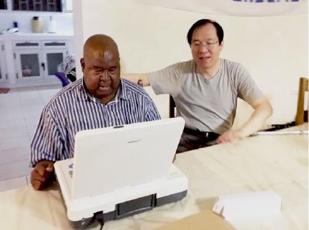 Dr. Idrissa Faye and Dr. Jun Xu inspecting a color ultrasound machine