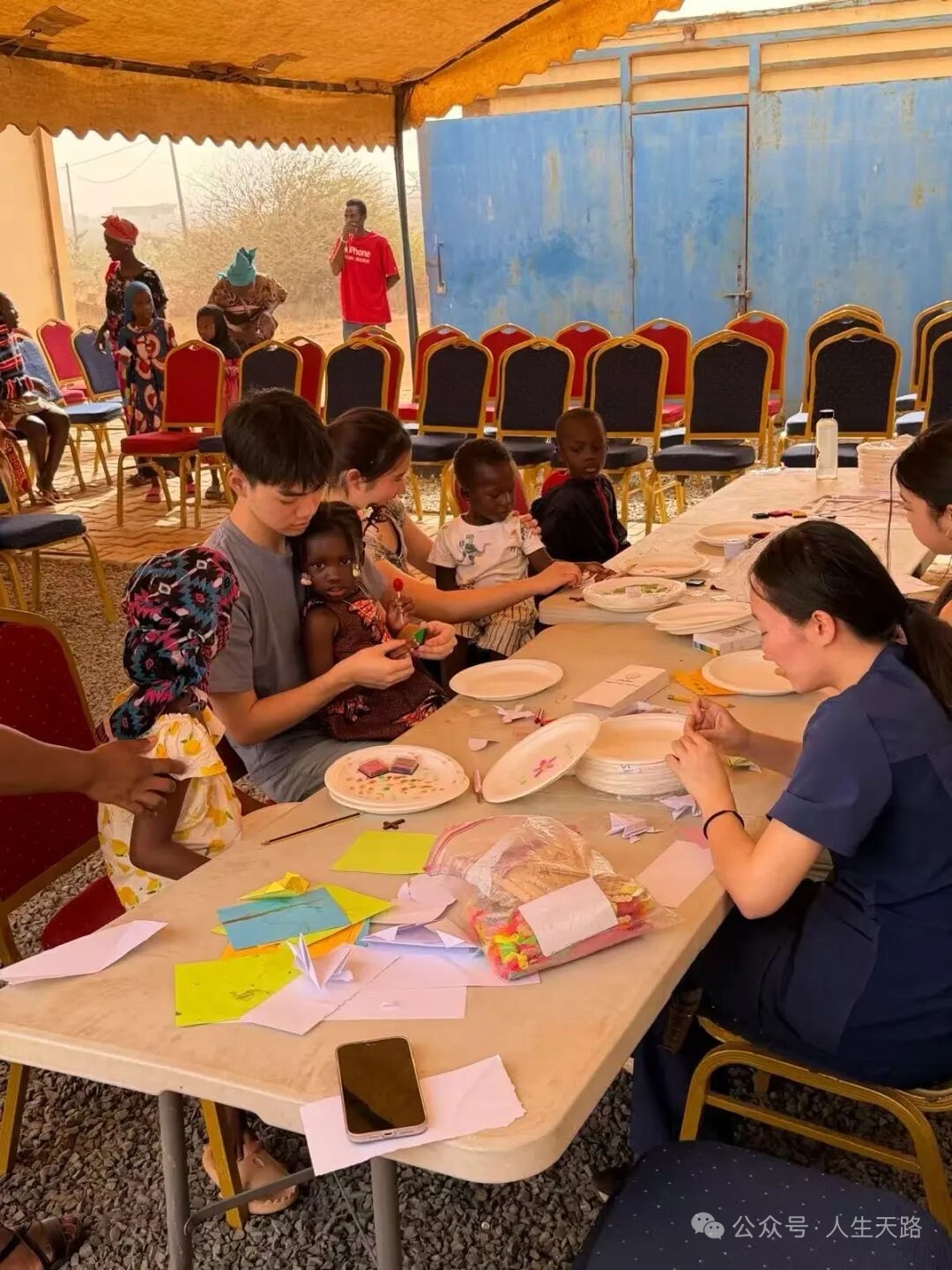 Volunteers and children creating crafts together during an ACO outreach.